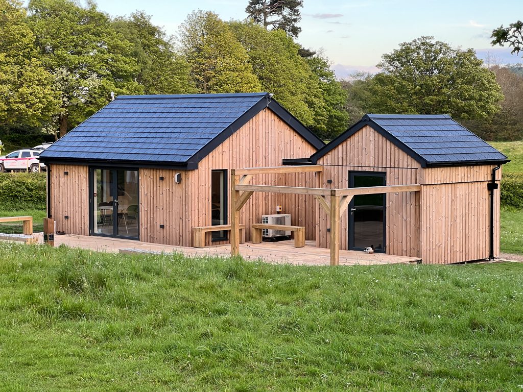 A stunning observatory complex clad in vertical timber and featuring an observatory and a classroom building, joined by a link bridge.